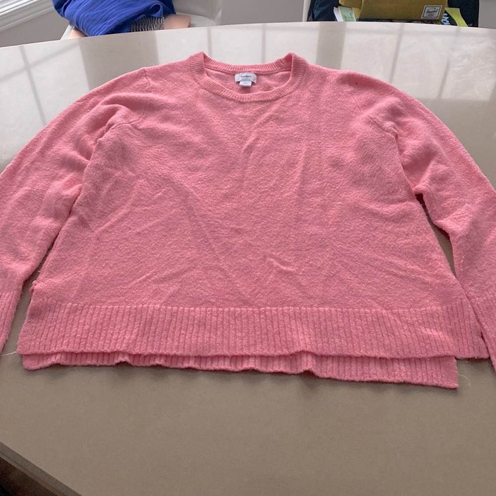 Pink knitted sweater with ribbing.